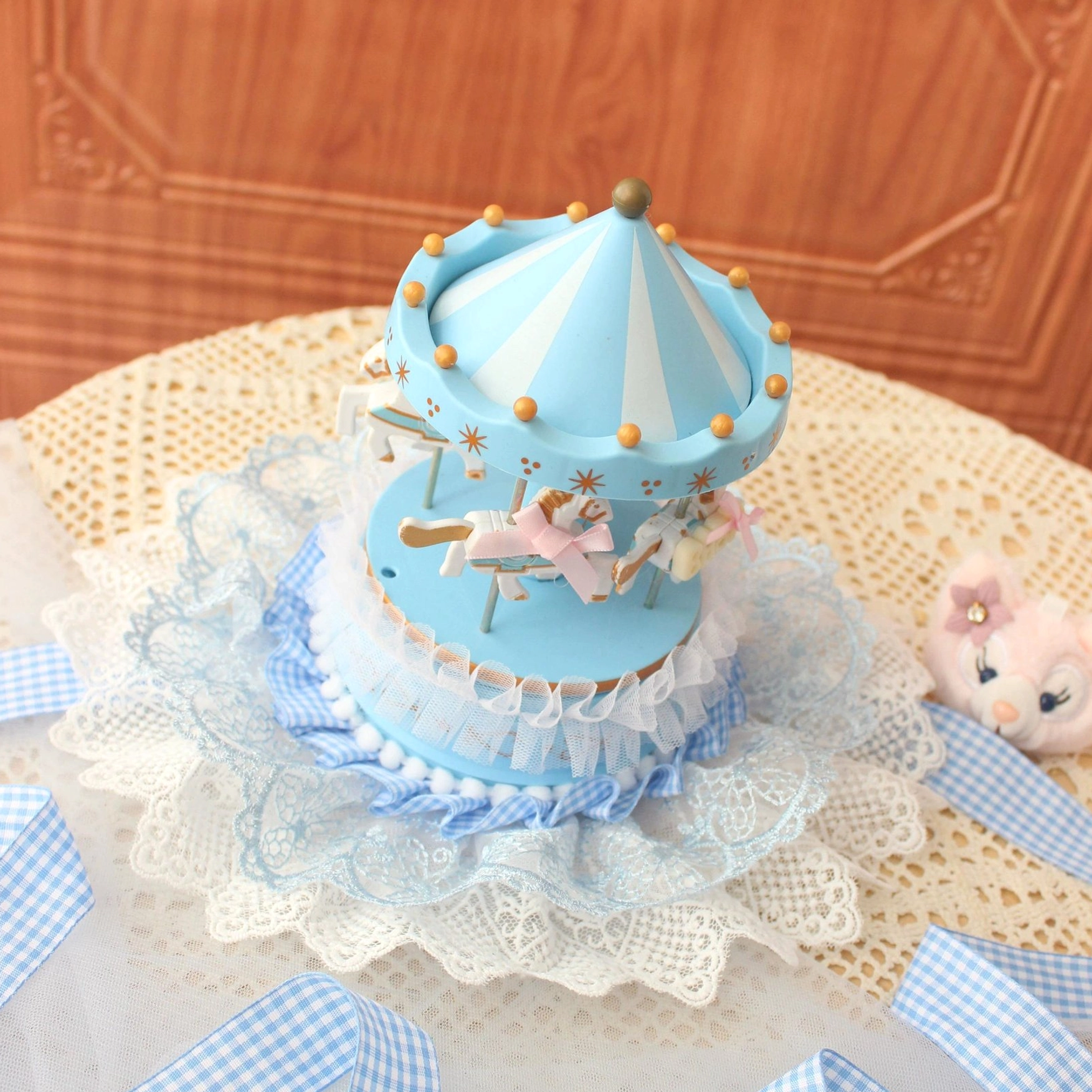 Sky blue lolita carousel mini top hat front close-up flat lay showing pink silk bows carousel horses gold spherical trim tent edge details