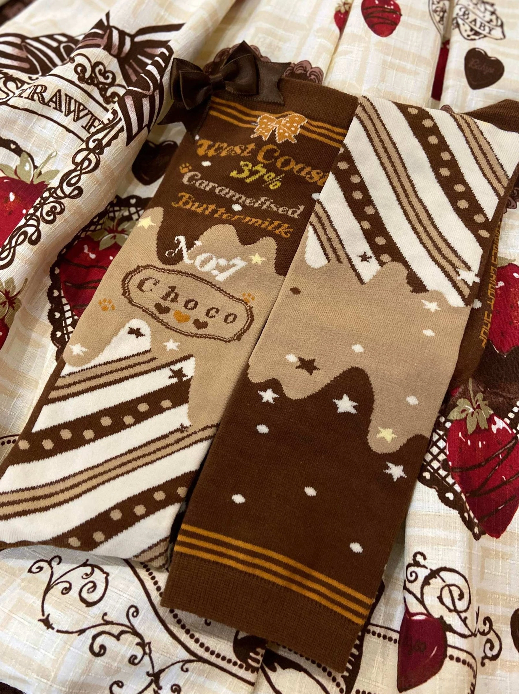 Single pair chocolate lolita cotton socks with strawberry print fabric close-up showing starry chocolate drip design details