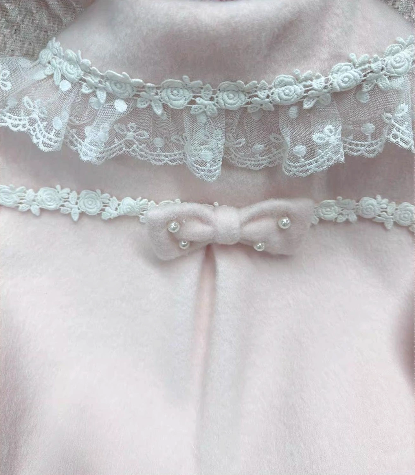 Close-up detail shot of lace peter pan collar lace-trimmed cuffs and fabric-covered buttons on sweet lolita wool coat