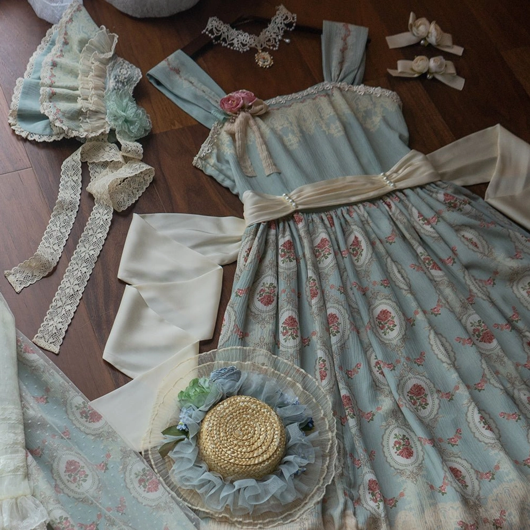 complete lolita accessory set flat lay overhead view on wooden table with sky blue floral jsk straw hat lace choker hair bows waist sashes