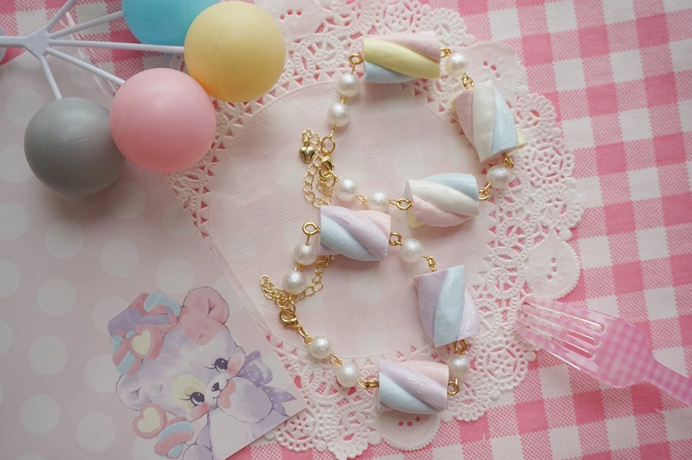 Matching pair of sweet lolita cotton candy clay bracelets in coordinating pastel colors displayed together showing bracelet set versatility with cartoon background props and decorative elements