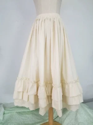 Classic lolita cotton petticoat with double-layer ruffle hem and embroidered lace trim in beige displayed on dress mannequin full front view
