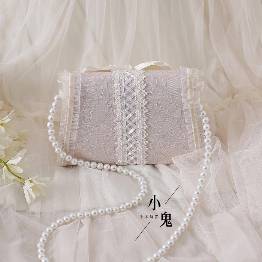 Light pink jacquard lolita handbag with ivory lace trim and matching pearl chain strap, front flat body view tulle background