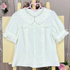 Single milky white vintage lolita doll collar shirt flat laid on wooden display board with smooth chiffon fabric and front pearl button placket shown in direct front view