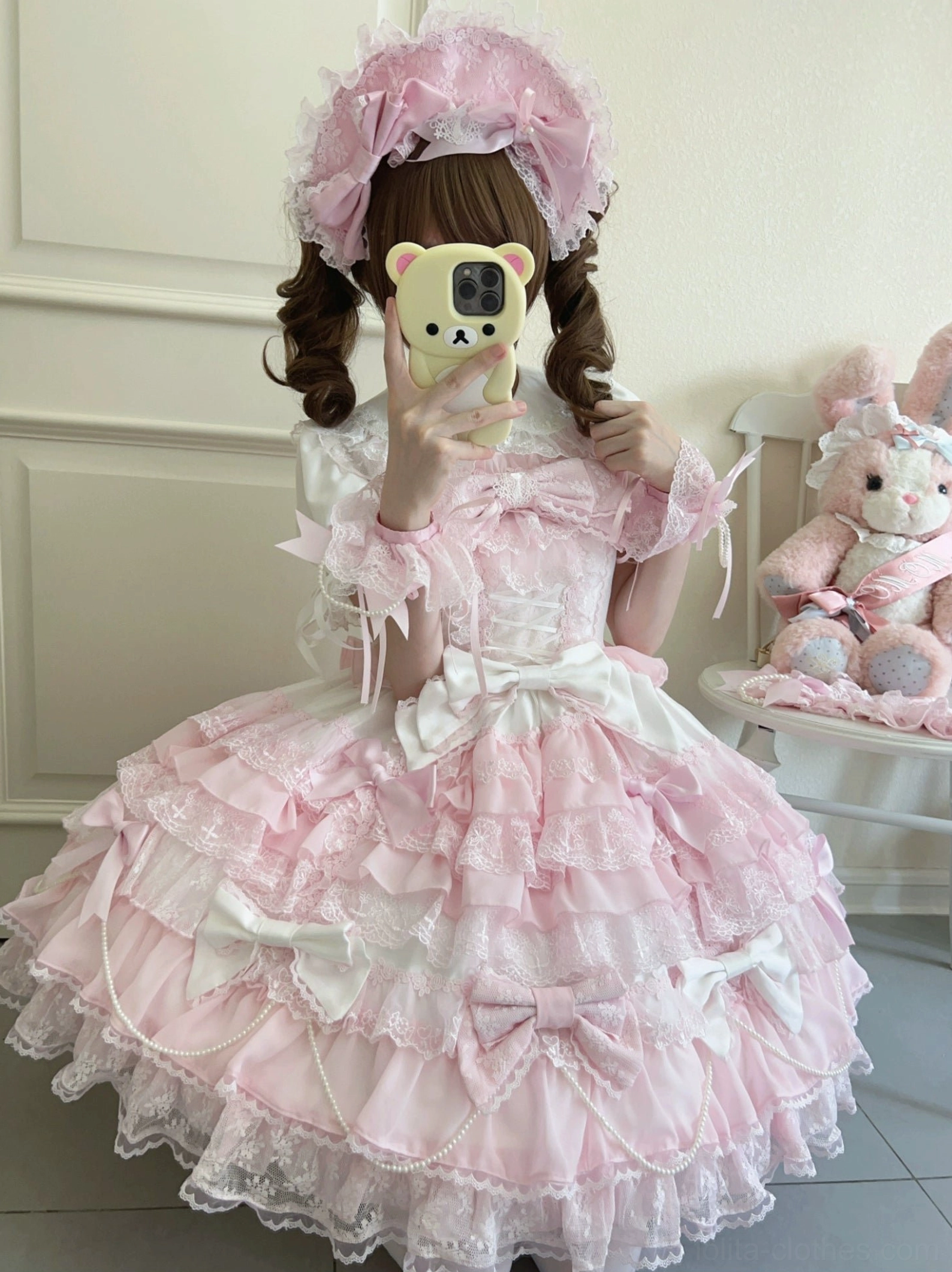Female model mirror selfie in lolita dress full-length twin curly buns hairstyle with matching headbow tiered lace skirt multiple satin bows stuffed rabbit plush