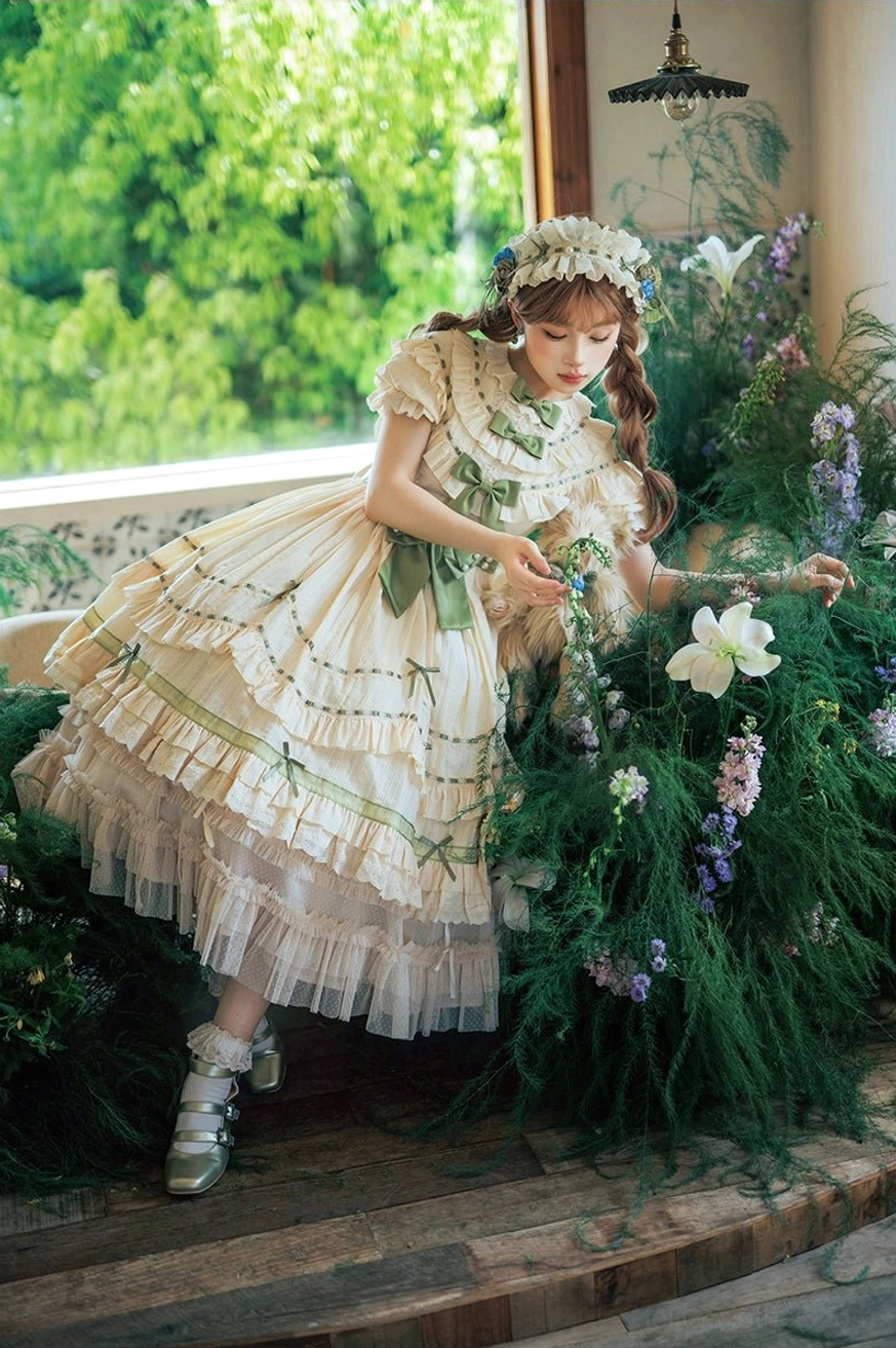 Three-quarter side view of lily of the valley lolita dress showing tiered ruffle hem with tulle underskirt and green sash worn with Mary Jane shoes