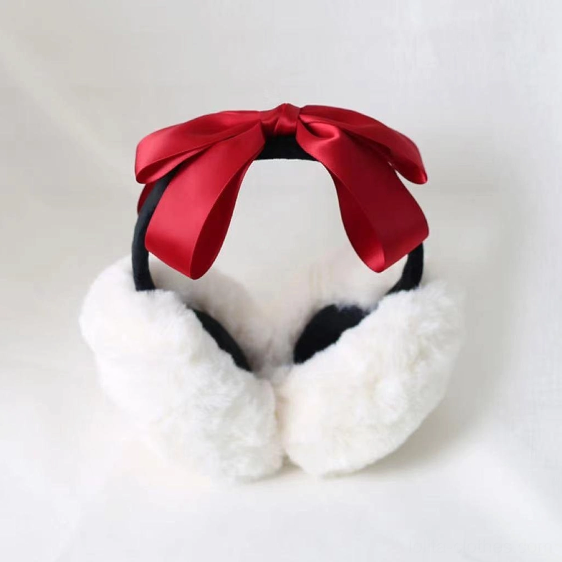 Lolita winter earmuff headdress flat product photography, bright red satin bow, white fluffy earmuff cups with black interior base, product display