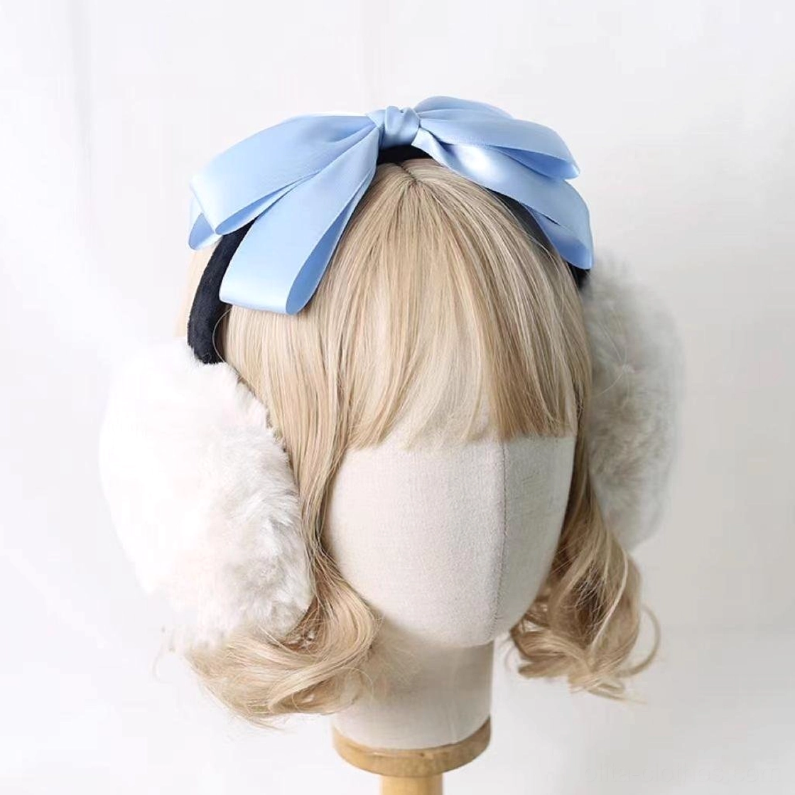 Lolita winter headdress earmuff with bright sky blue satin bow, white plush ear cups, black headband base, worn on blonde mannequin front view