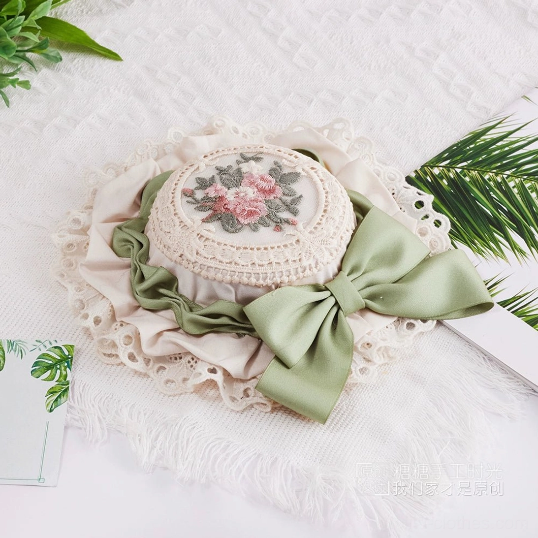 Delicate Lolita fashion headpiece featuring miniature top hat silhouette with coordinated color satin bow and botanical floral embroidery centerpiece