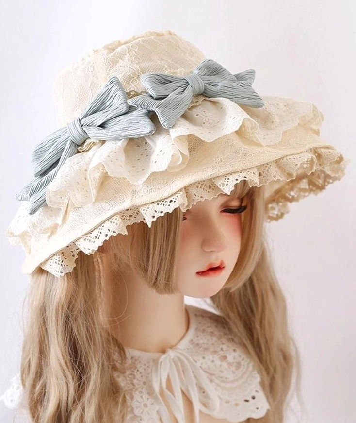 Beige embroidered lace Lolita sun headdress with sky-blue bows on BJD model, right three-quarter angle showing layered ruffled lace trim detail