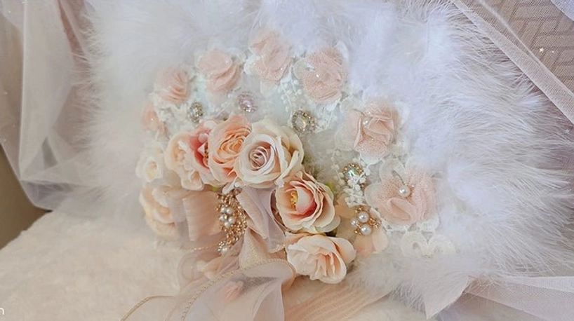 Handmade Lolita tea party feather fan with intricate flower and gem decoration on white feather fan base, flat lay close-up view on plush fabric and tulle background, craftsmanship showcase