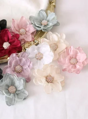 Close-up lolita organza flower hair clips with pearl-studded centers soft pastel tones