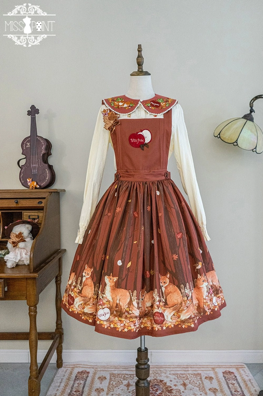 Full lolita coordinate styling brown overall dress fox print hem matching embroidered peter pan collar white long sleeve blouse vintage indoor studio setting