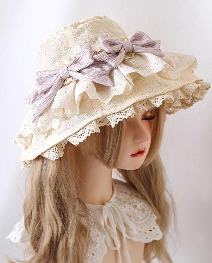 Lolita sun hat in beige with light purple bows on BJD mannequin, front three-quarter view with twin curly wig and lace collar accent