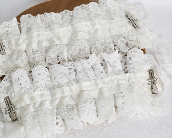 Unfinished lolita lace headdress components flat lay view on wooden round base, all-over ruffled lace fabric showing multi-layered frill structure without fixed clips or straps attachment