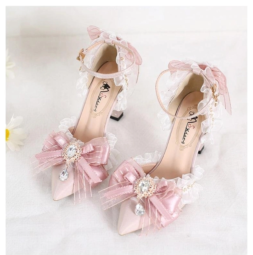 Back overhead close-up view of finished pink lolita heels featuring sheer pink ribbon bows with white embroidered butterfly appliqués and solid pink block heel construction on light background
