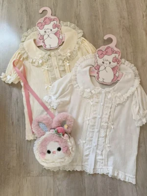 Two lolita cotton blouses with detachable hime sleeves and lace-trimmed peter pan collars featuring front button plackets with ruffle trims