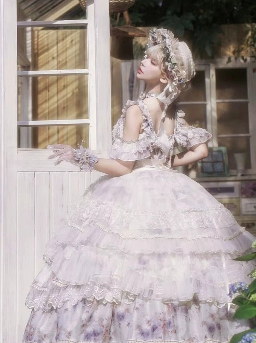 Back full-body shot of lolita princess gown featuring adjustable shirring back with lace-up straps, ruffled off-shoulder design and multi-layered lace-decorated skirt at white french window
