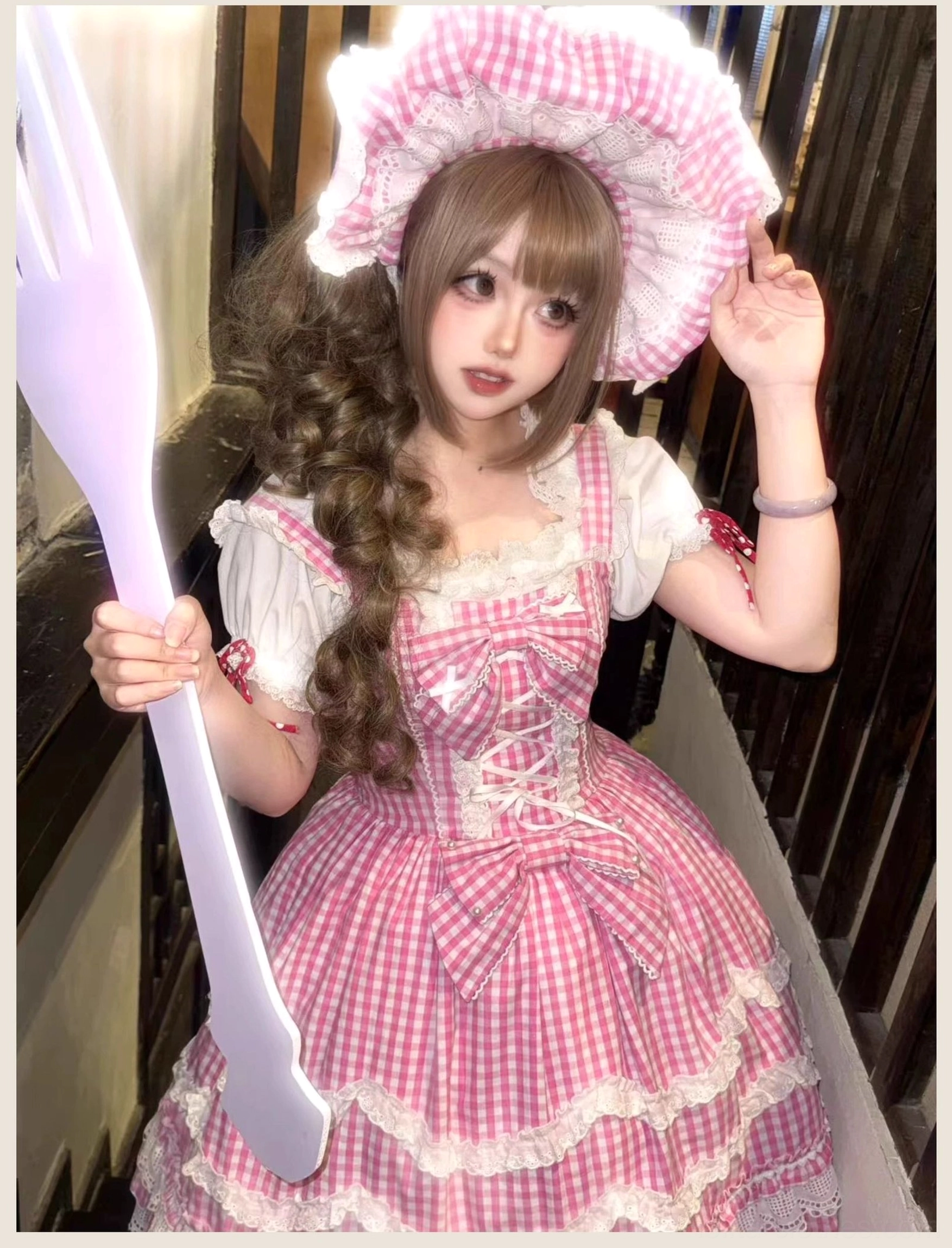 Old school Lolita jumper skirt dress in pink gingham pattern, top bodice area close-up showing lace-up corset design and decorative lace trim around neckline and armholes