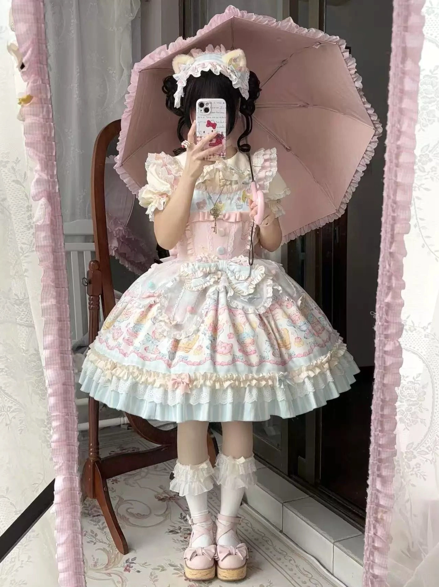 Lolita jsk dress front full-body model view indoor setting pink umbrella cat ear headdress ruffled socks