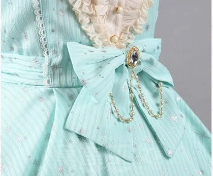 Mint green lolita dress close-up detail waist area large fabric bow gem brooch hanging chain tiny silver star foil prints vertical stripe fabric