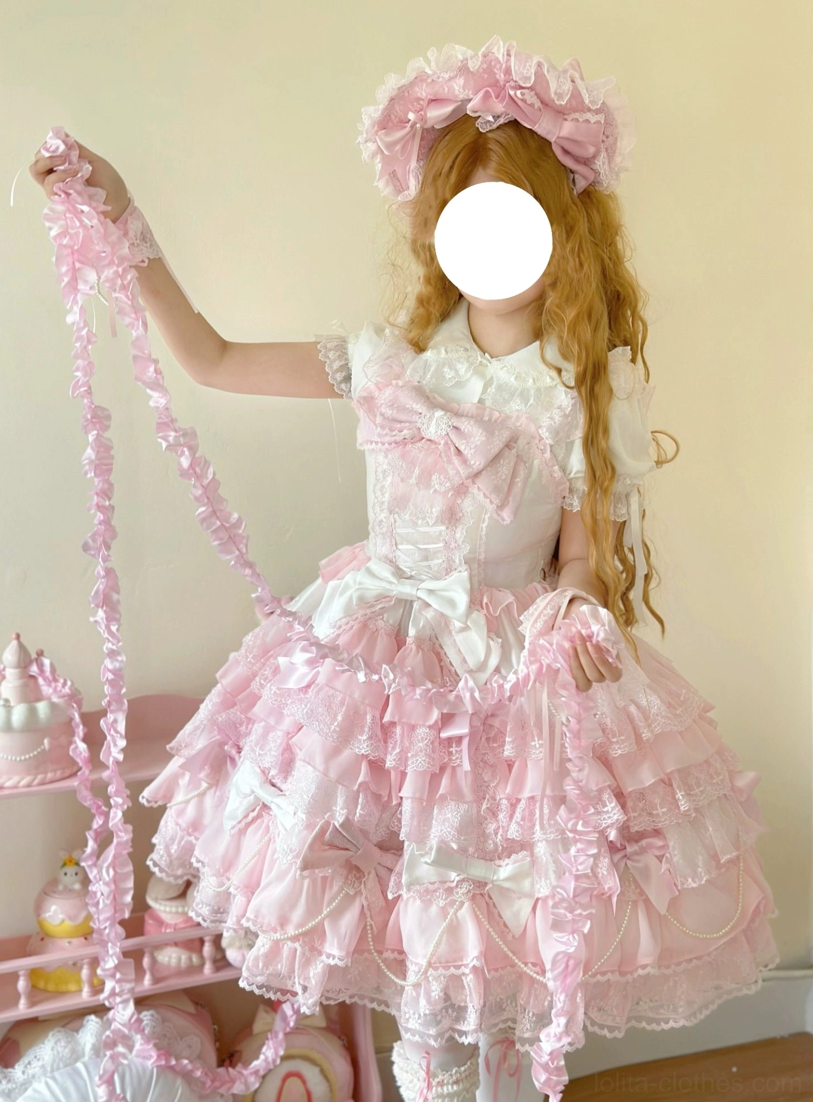 Female model posing in pink lolita dress half and full-length indoor shots featuring peter pan collar large front satin bow layered ruffled skirt with lace pink garland prop