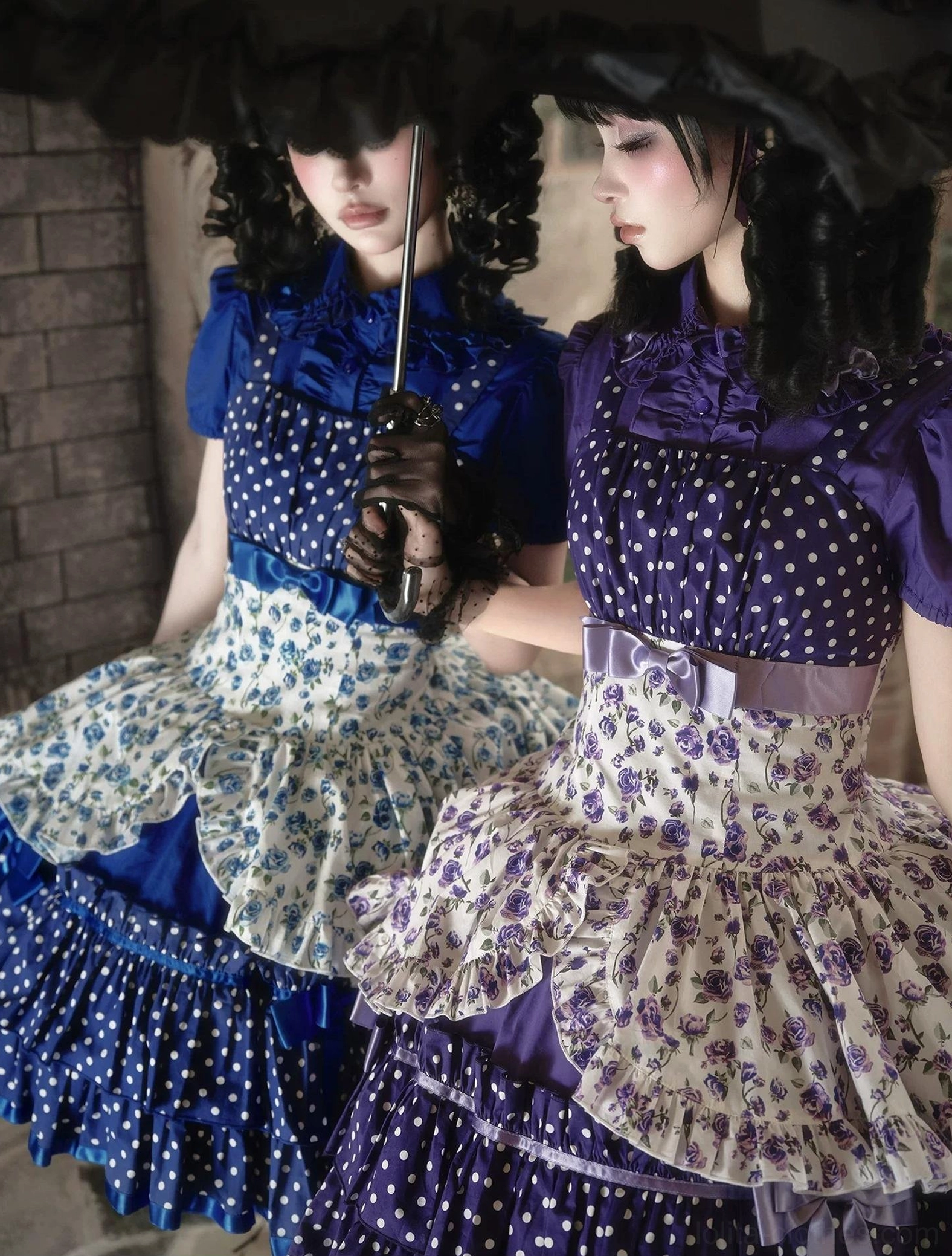 Close-up detail view of blue and purple old school Lolita JSK dresses showing polka dot bodice, floral print apron panel, multi-tiered ruffled hem with satin ribbon bow trims and elastic waist construction