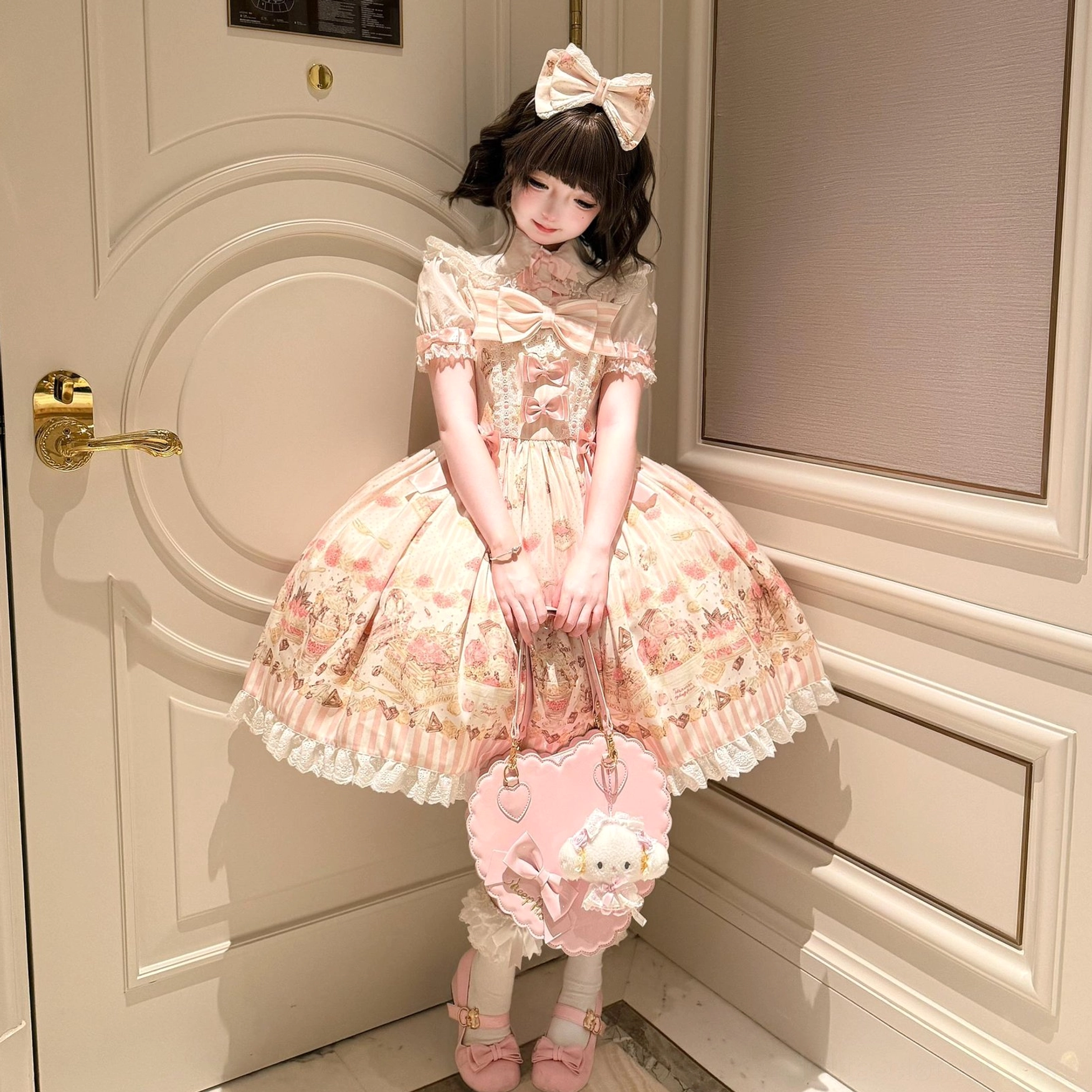 Sweet Lolita girl wearing Iced Strawberry Cheese JSK dress front half-length portrait black curly hair pink bow hairpin kitten handbag pink Mary Jane shoes corridor setting