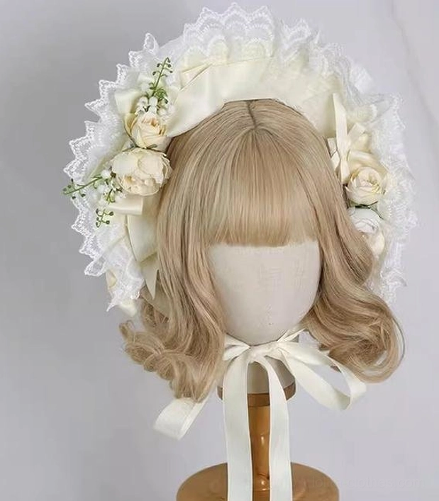Front full view of cream lolita bonnet with complete ruffled lace brim, artificial roses and lily of the valley decorations, long cream neck tie straps
