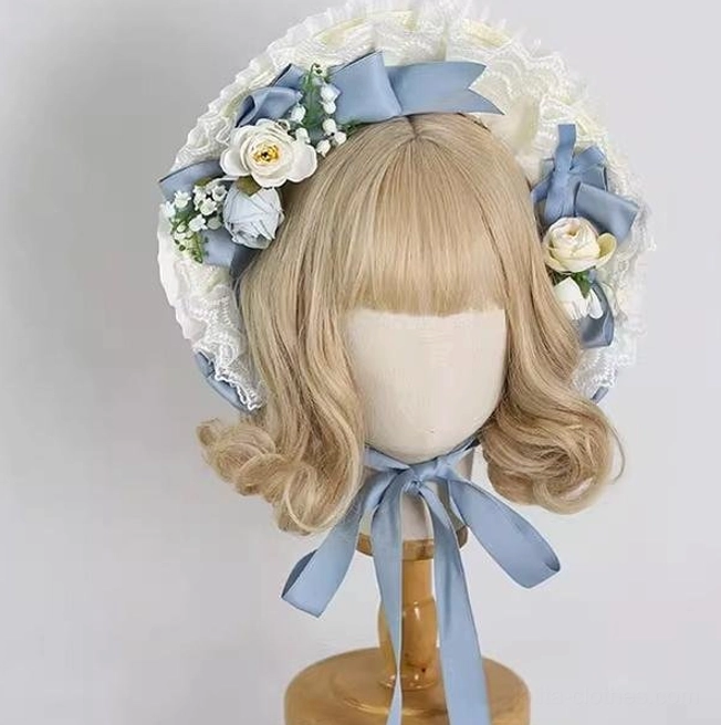 Front view of gray-blue lolita bonnet with full ruffled lace brim, matching satin bows, and adjustable long neck tie straps on display mannequin