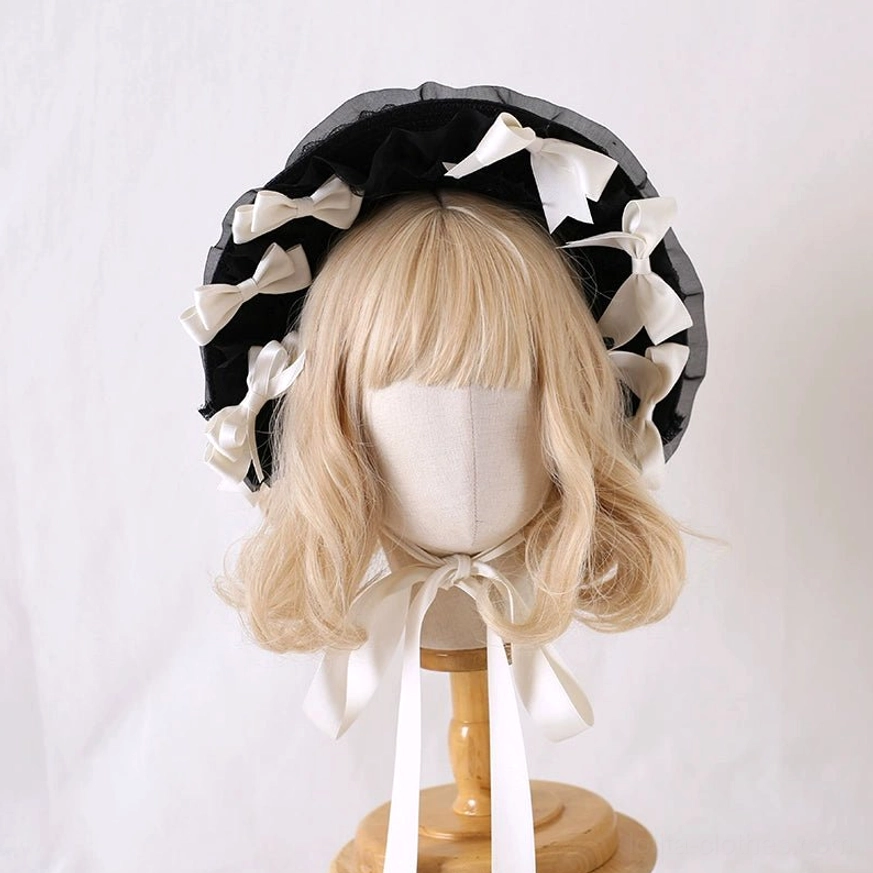 White milky lolita lace bonnet hat with black ruffled trim and white satin bows front display mannequin