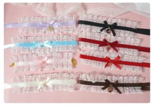 Assorted eight-color lolita lace bow bracelets with fruit charm pendants, flat lay overhead view showcasing all color variations including pink, purple, wine red, black, blue and more