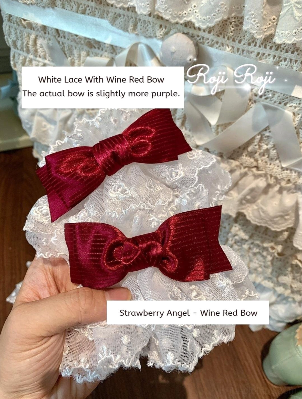 Detail view of wine red satin bow Sweet Lolita wrist cuffs on delicate white lace base