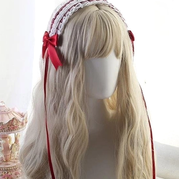 Classic lolita hair accessory featuring dark navy satin bow with white lace headband and long black ribbon tail, three-quarter angle