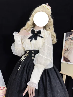 Vintage Lolita lantern sleeve blouse with embroidered lace chest panel worn with black high-waisted skirt and matching black bow tie, three-quarter front view on faceless doll model with blonde curly wig and flower hair accessory