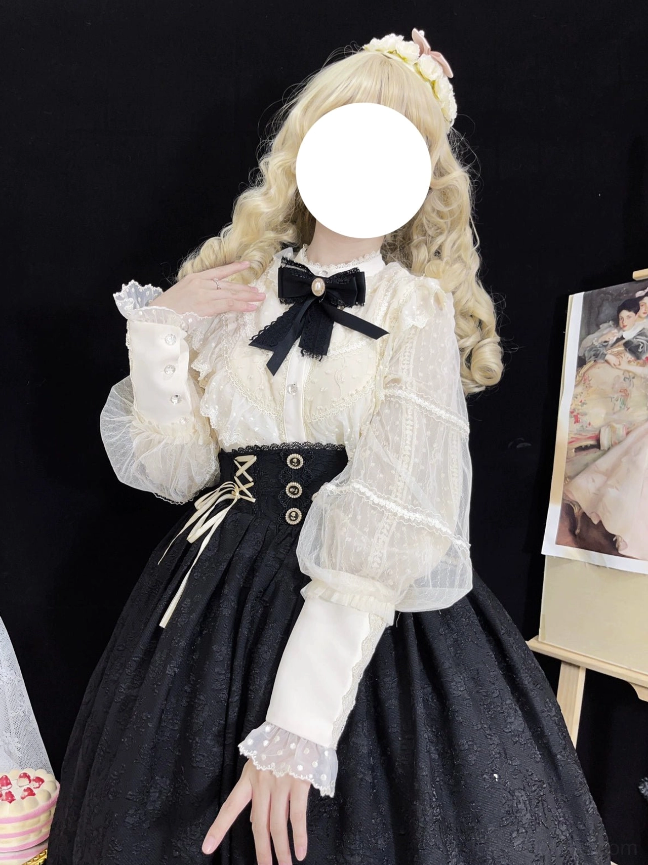 Vintage Lolita lantern sleeve blouse with embroidered lace chest panel worn with black high-waisted skirt and matching black bow tie, three-quarter front view on faceless doll model with blonde curly wig and flower hair accessory