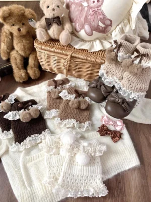 Kawaii lolita knit leg warmers with pom-pom bows and lace ruffles in multiple colors displayed on vintage dollhouse table setting with teddy bear props