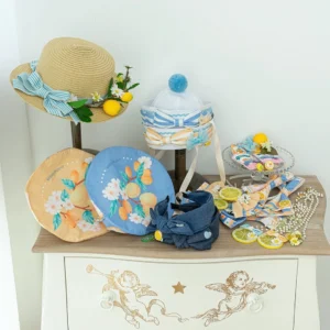 Assorted lolita lemon flower accessories collection overhead display featuring straw hats fabric bows hair clips pom-pom berets lemon fruit ornaments white flowers vintage dresser styling