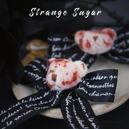 Lettered black bow with bloody bear charm lolita hair clips handwritten text white lettering on dark round display tray