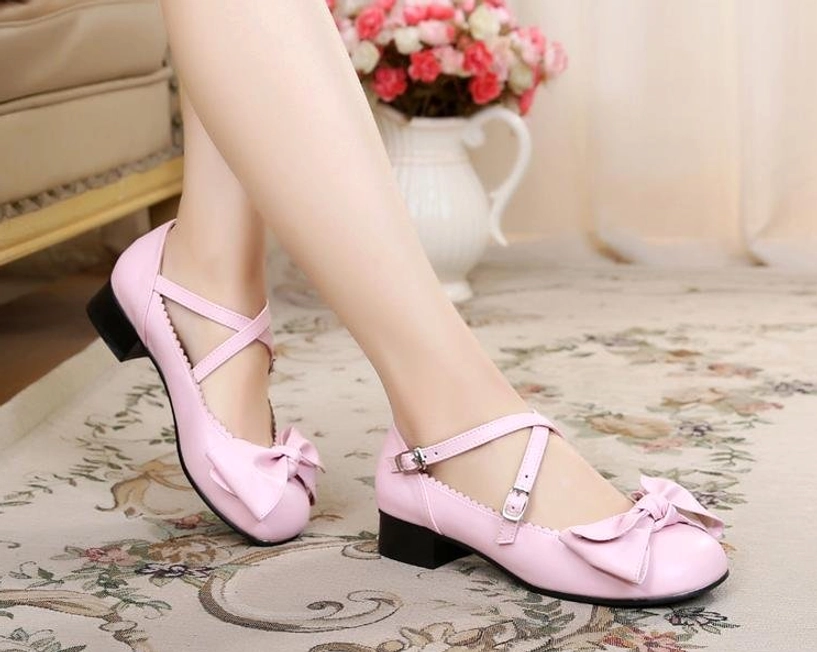 Gold lolita bow cross-strap shoes three-quarter angle showing crisscross strap design