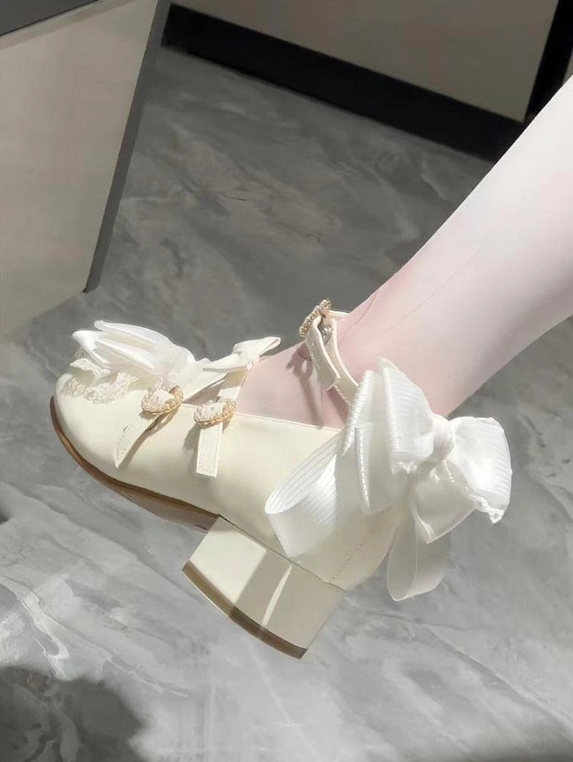 Off-white Lolita Mary Jane shoes on model foot side close-up perspective large satin back bow ruffled lace toe cap gem-studded strap buckles white stockings