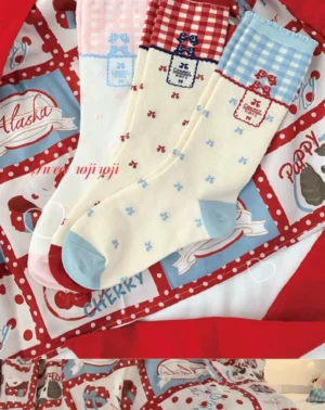 Three pairs gingham lolita mid-calf socks close-up flat lay showing blue gingham cuffs pink ruffled cuff bow-dot embellishments light blue reinforced toe caps retro fabric tags on vintage printed tablecloth
