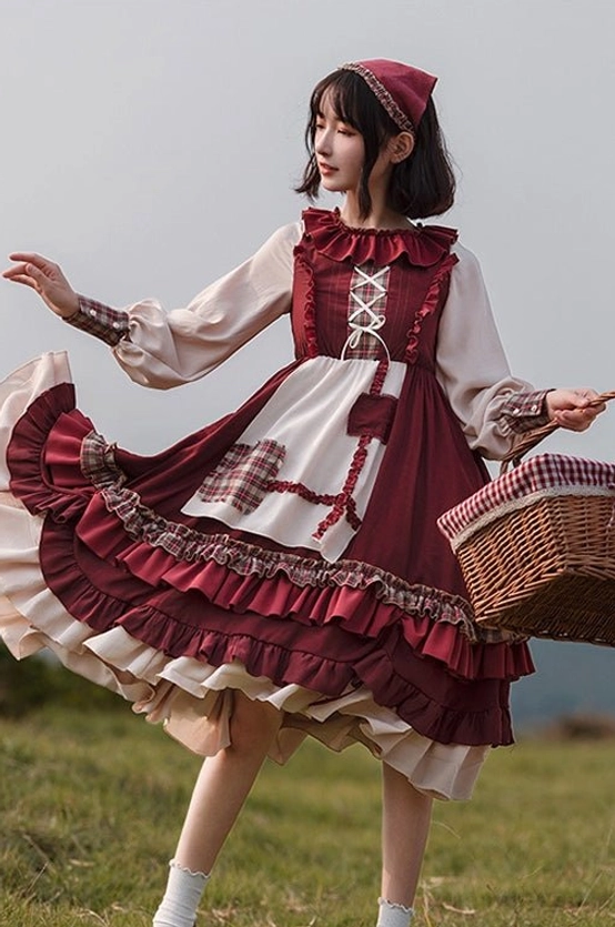 Multiple close-up product detail shots showing lace-up bust detail on OP dress, ruffled hem trims, plaid cuffs, and back strap detail of hooded cape in flat lay arrangement