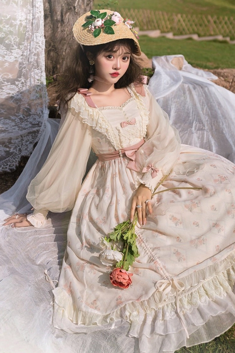 Lolita OP dress sleeve detail showing sheer puffed lantern sleeve construction, lace trim cuff, transparent mesh fabric, delicate pink floral print, romantic sleeve design