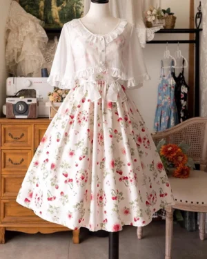 Complete Lolita coordinate featuring red berry print midi dress with matching white ruffled cropped cardigan, elegant A-line silhouette with vintage furniture studio backdrop