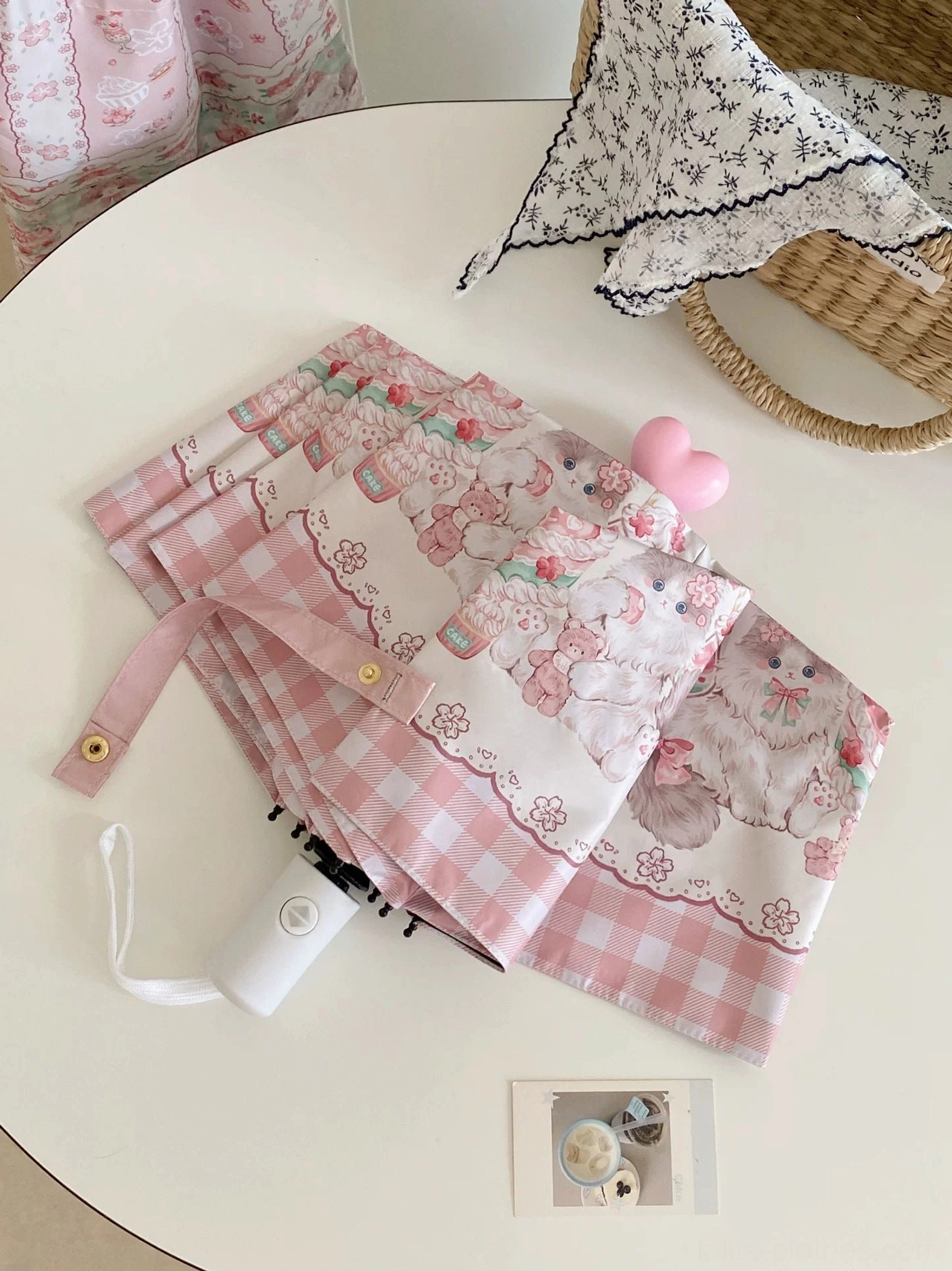 Automatic cat printed lolita parasol with red top button and gingham border in flat lay tabletop display