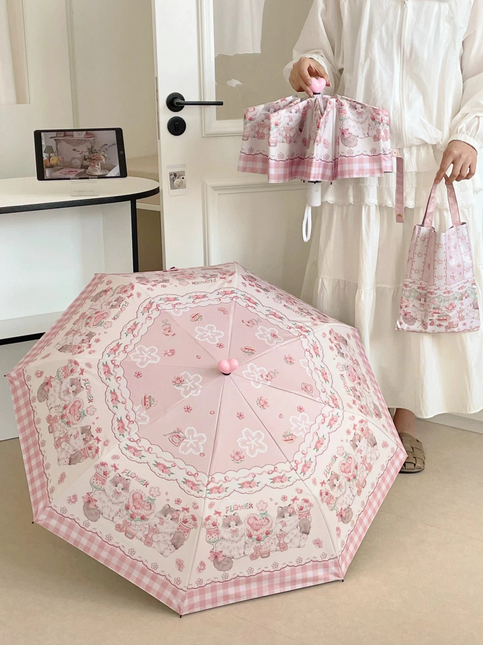 Girl holding both folded and opened pink lolita parasol in doorway display showing compact portability