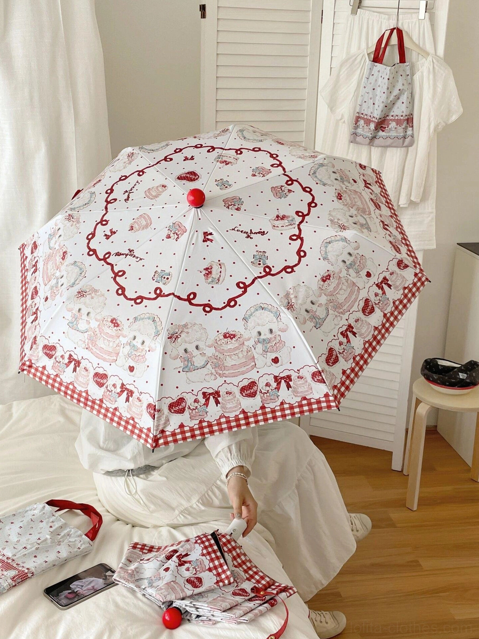 Two-section lamb print lolita parasol with red gingham edge overhead view on wooden floor bedroom setting