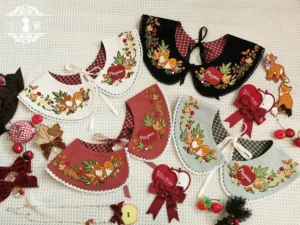 Assorted embroidered lolita peter pan collars with fox and forest plant patterns mixed plaid fabric lining lace trim details flat lay styling with decorative bows