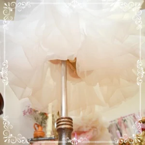 Close-up bottom hem detail of white lolita petticoat showing fluffy layered organza tulle fabric with ruffled edge trim construction